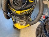 un aspirateur posé par terre à côté d'un enchevêtrement de fils