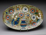 a decorative plate with flowers and a bird on it