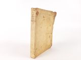 an old book sitting on top of a white table next to a white wall