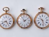 trois types différents de montres de poche exposées sur un fond blanc