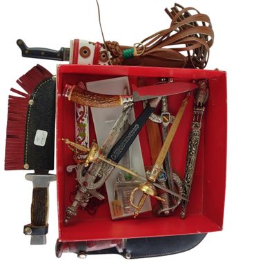 une boîte rouge remplie d'objets divers posée sur une surface blanche