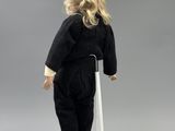 a small doll that is standing on a white stand