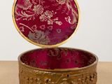 a red box with a gold lid on a table