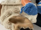 a doll that is laying on the ground with a glove