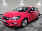 Une Opel rouge est garée dans une pièce au sol carrelé en damier.