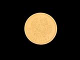 a close up of a gold coin on a black background
