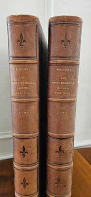 two old books sitting on top of a wooden table next to each other