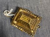 une image représentant un pendentif plaqué or orné d'une croix