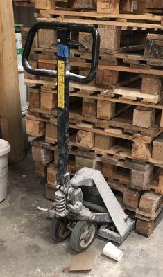 a pallet that is sitting in front of a stack of wood pallets