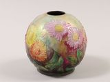 a colorful vase with flowers painted on it on a white surface