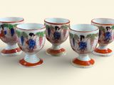 quatre tasses ornées d'une image représentant des personnes sont alignées sur une table