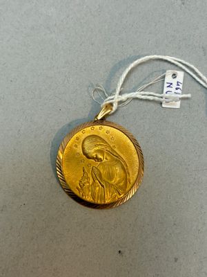 une médaille d'or avec la photo d'une femme dessus