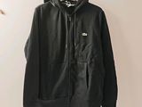 une veste noire accrochée au mur à côté d'un cintre