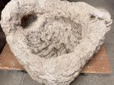 a large stone bowl sitting on top of a piece of wood
