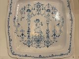 une assiette bleue et blanche accrochée au mur au-dessus d'un évier