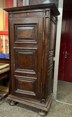 a tall wooden cabinet sitting in the corner of a room
