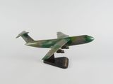 une petite maquette d'avion posée sur une surface blanche