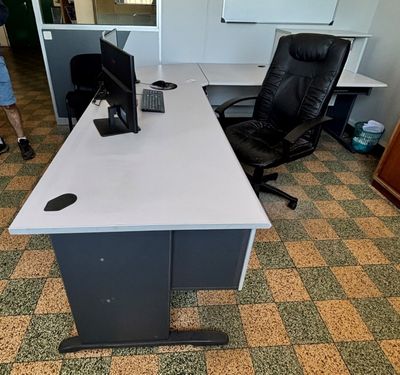 un bureau avec un ordinateur et une chaise dans une pièce