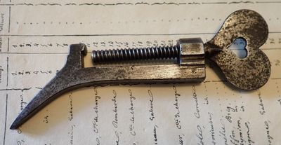 un coupe-tube métallique posé sur une feuille de papier