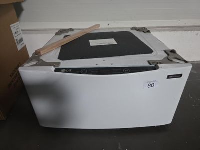 un lave-vaisselle blanc posé par terre à côté d'un carton