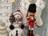 a snowman, a nutcracker and a christmas stocking on a table