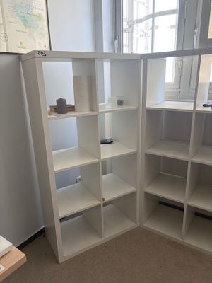 a corner of a room with a desk and a bookcase