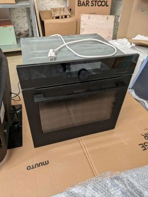 un micro-ondes posé sur une boîte au milieu d'une pièce