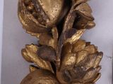 a gold figurine of pomegranates on a branch