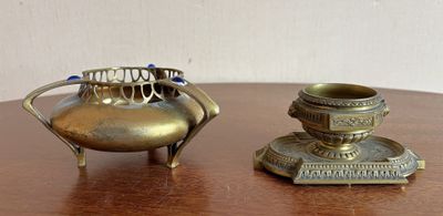 une petite théière en laiton et une petite théière en argent posées sur une table