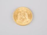 a close up of a gold coin on a white surface