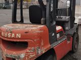 a red forklift truck parked in a parking lot