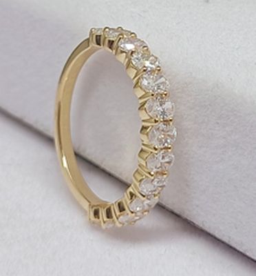 gros plan d'une bague en or avec des diamants sur une surface blanche