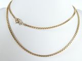a close up of a gold necklace on a mannequin mannequin