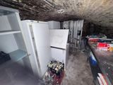an image of a kitchen with a refrigerator in the middle of the room
