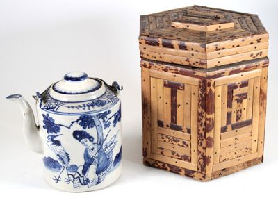 une théière bleue et blanche à côté d'une boîte en bois