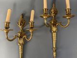 pair of antique brass wall sconces with candles on each of them