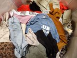 a pile of clothes in a trash can on the floor