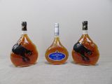 trois bouteilles d'alcool sur lesquelles figure l'image d'un cheval