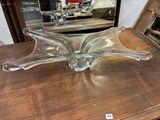 a glass bowl sitting on a table with a mirror in the background