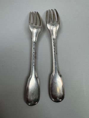 two forks that are sitting next to each other on a table