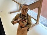 a statue of a man holding a knife in a room