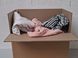 une boîte en carton contenant des vêtements, posée sur une table