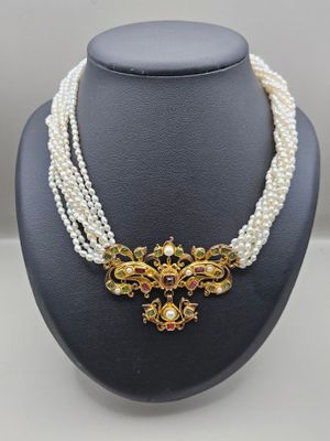un collier de perles blanches avec un fermoir en or et un collier de perles multicolores
