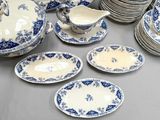 many plates and bowls on the table with blue and white designs