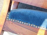 a wooden chair with a blue velvet cushion on it