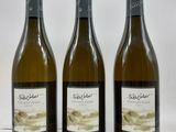 trois bouteilles de vin posées sur une table blanche