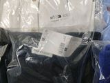 several pairs of men ' s shirts are wrapped in plastic bags