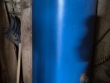un grand réservoir d'eau bleu posé dans un coin d'une pièce