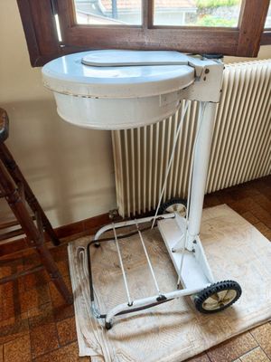 a white toilet sitting on top of a cart in front of a window