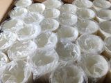 une boîte en carton remplie de gobelets en plastique et enveloppée dans du film alimentaire
